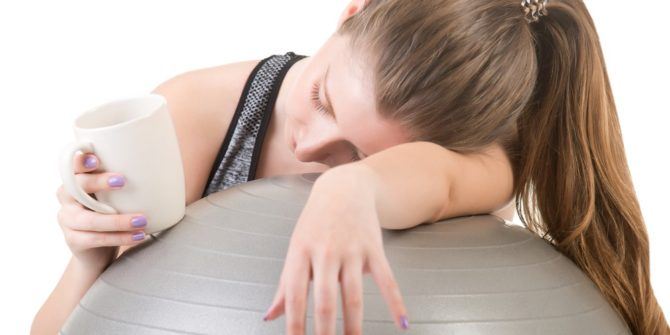 femme endormie sur un ballon qui manque d'énergie, un café à la main